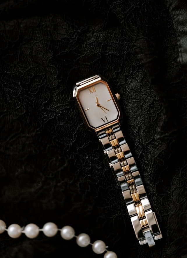 Gold and silver watch on lace with pearls